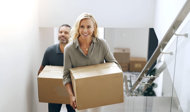 real estate moving house couple carrying box upstairs while relocating their new home 1176719 1049